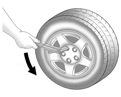 Loosening wheel nuts with wrench before lifting vehicle